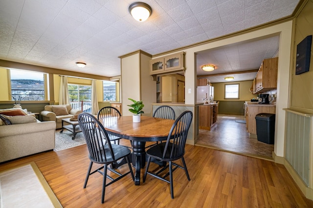 dining room with light hardwood / wood-style floors and ornamental molding