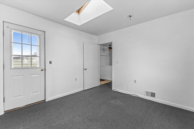 carpeted empty room with ceiling fan and a skylight