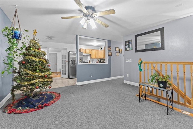 interior space featuring light colored carpet and ceiling fan