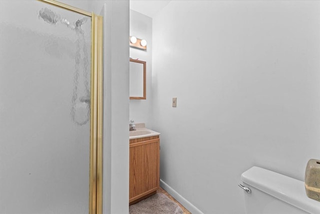 bathroom featuring vanity, toilet, and a shower with door