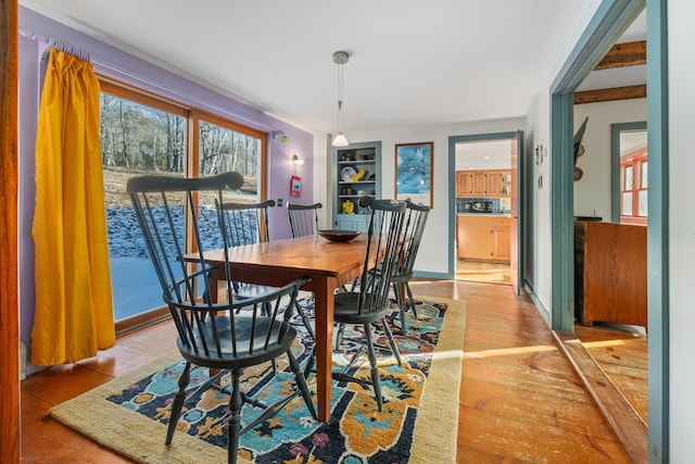 dining area with built in shelves and light hardwood / wood-style floors