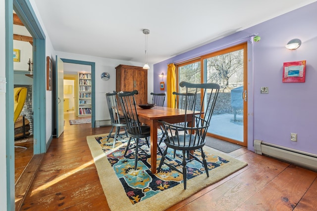 dining area with dark wood-type flooring and a baseboard radiator