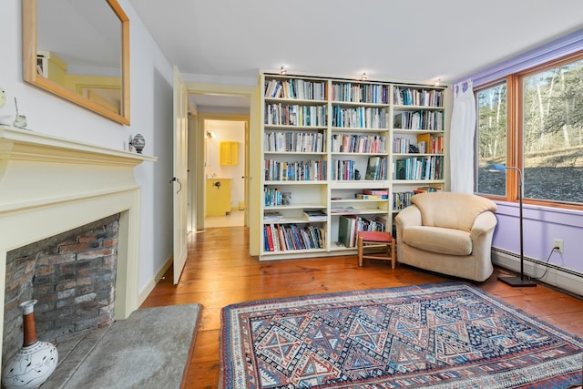 living area with wood-type flooring and a baseboard radiator