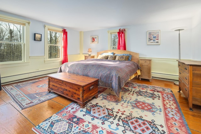 bedroom featuring baseboard heating and light hardwood / wood-style flooring