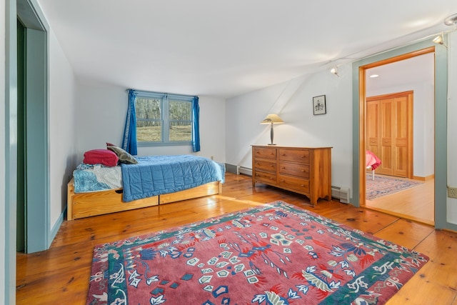 bedroom featuring wood-type flooring and baseboard heating