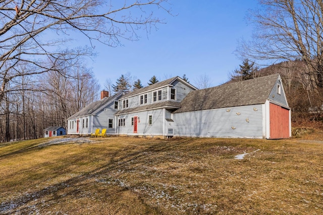 front facade featuring an outbuilding and a front lawn