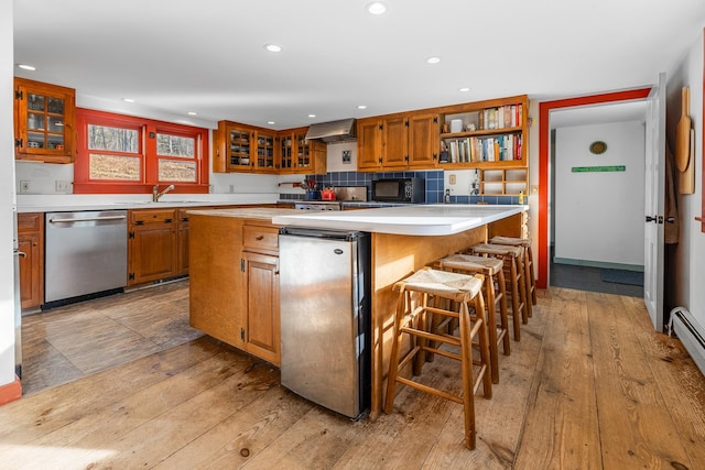 kitchen featuring light hardwood / wood-style floors, exhaust hood, dishwasher, and a center island