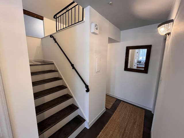 staircase with a notable chandelier