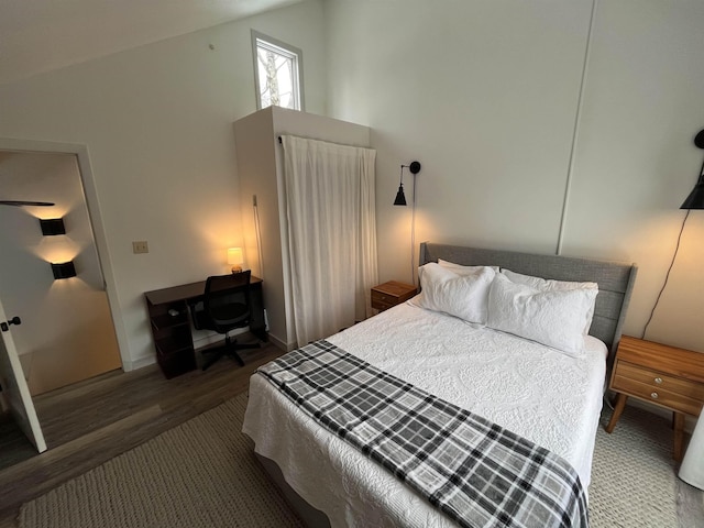 bedroom with dark hardwood / wood-style flooring and lofted ceiling