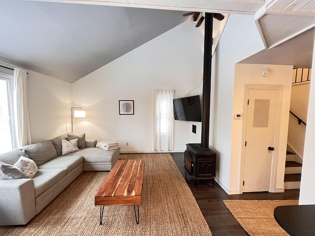 living room with lofted ceiling, a wood stove, and dark wood-type flooring