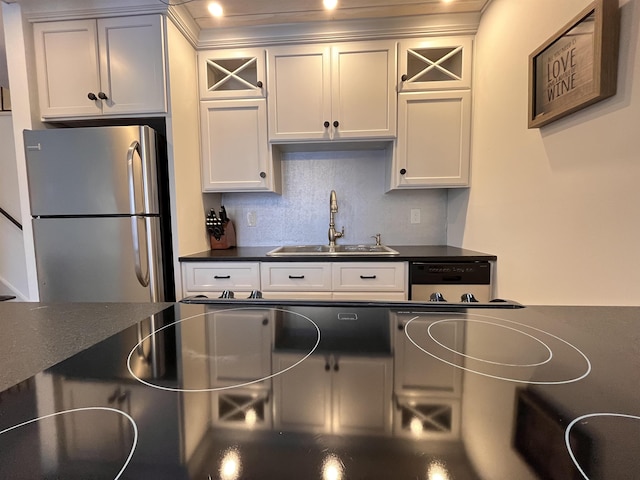 kitchen featuring white cabinetry, stainless steel refrigerator, and sink