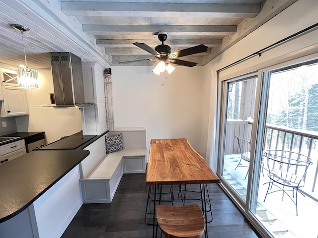 kitchen with beam ceiling, dark wood-type flooring, pendant lighting, white cabinets, and ceiling fan with notable chandelier