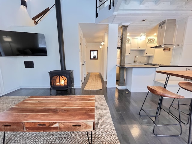 dining space with a wood stove and dark wood-type flooring