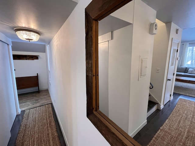 hallway with dark hardwood / wood-style flooring and an inviting chandelier