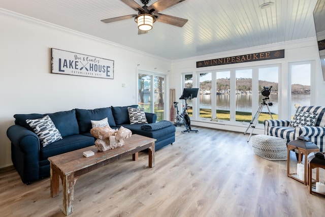 living room with ceiling fan, a water view, light wood-type flooring, and ornamental molding