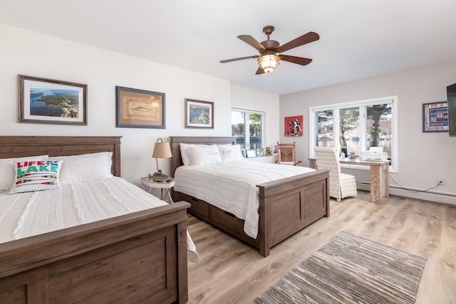 bedroom with ceiling fan, light hardwood / wood-style flooring, and a baseboard heating unit