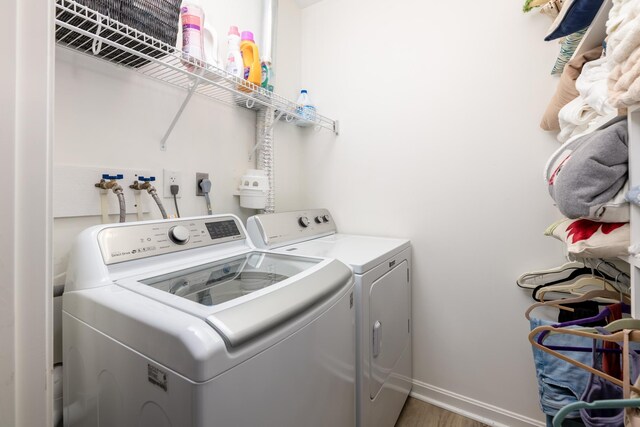 laundry room featuring washing machine and dryer and hardwood / wood-style flooring