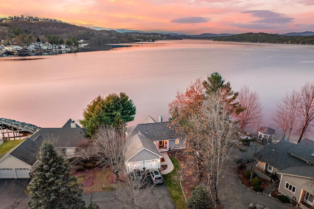 aerial view at dusk featuring a water view