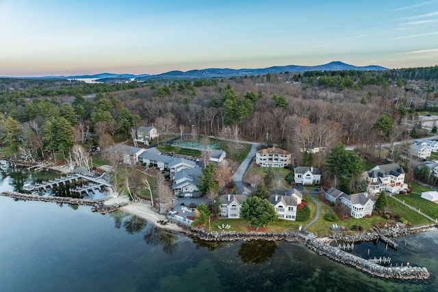 aerial view at dusk featuring a water and mountain view