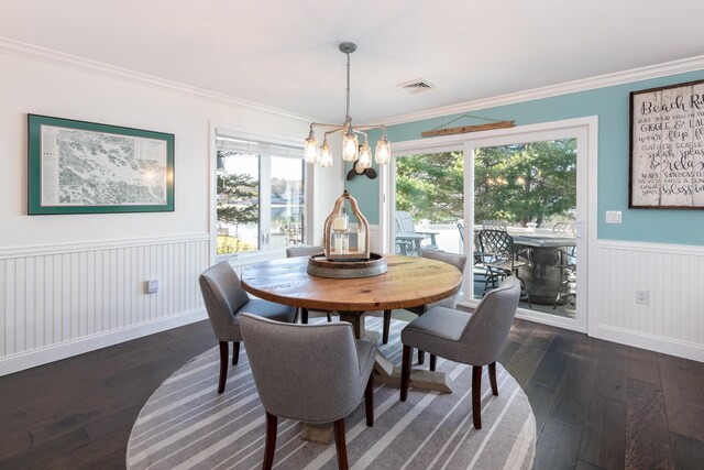 dining space featuring a notable chandelier, dark hardwood / wood-style floors, and ornamental molding