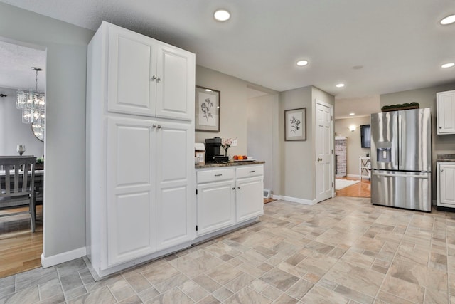 kitchen with white cabinets, a notable chandelier, pendant lighting, and stainless steel fridge with ice dispenser