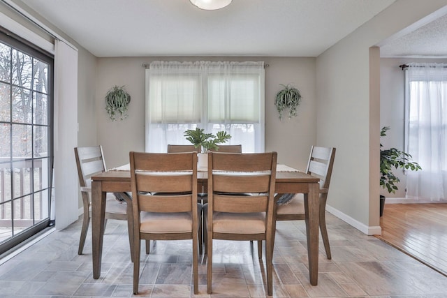 dining space featuring light hardwood / wood-style floors and a textured ceiling