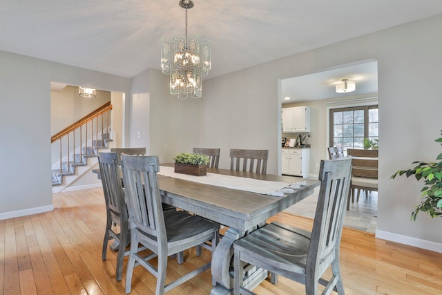 dining area featuring light hardwood / wood-style floors and an inviting chandelier