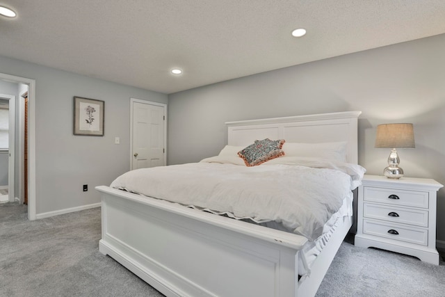 bedroom with light carpet and a textured ceiling