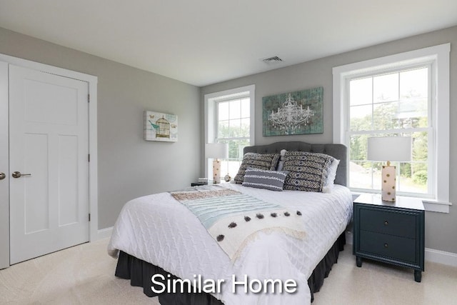 carpeted bedroom featuring multiple windows