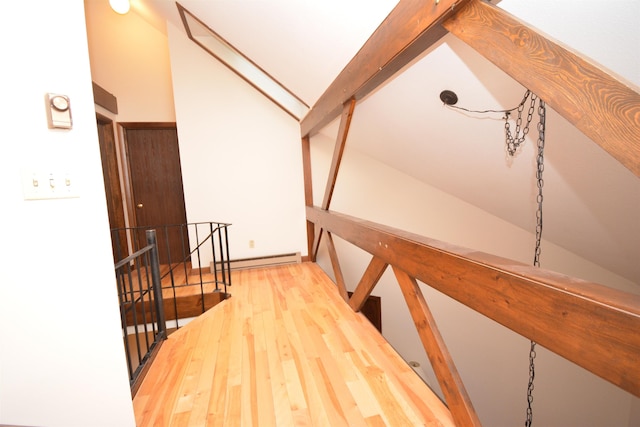 hall featuring hardwood / wood-style floors, vaulted ceiling, and a baseboard heating unit