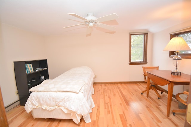 bedroom featuring baseboard heating, ceiling fan, light hardwood / wood-style floors, and lofted ceiling