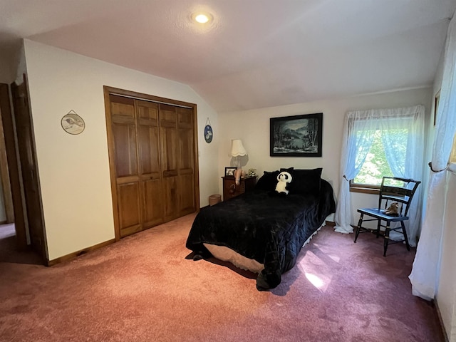 carpeted bedroom with lofted ceiling and a closet