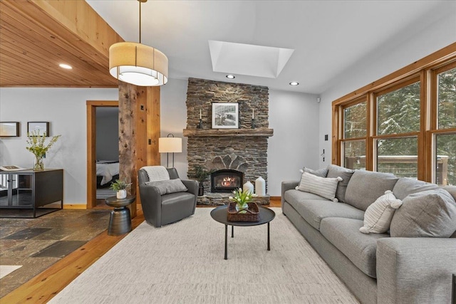 living room featuring a skylight, a wealth of natural light, a fireplace, and wood-type flooring