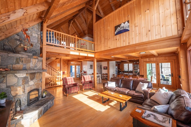 43 Upton Rd, Dover, VT 05356 - living room featuring high vaulted ceiling, wooden walls, plenty of natural light, wood finished floors, and a wooden ceiling with exposed beams