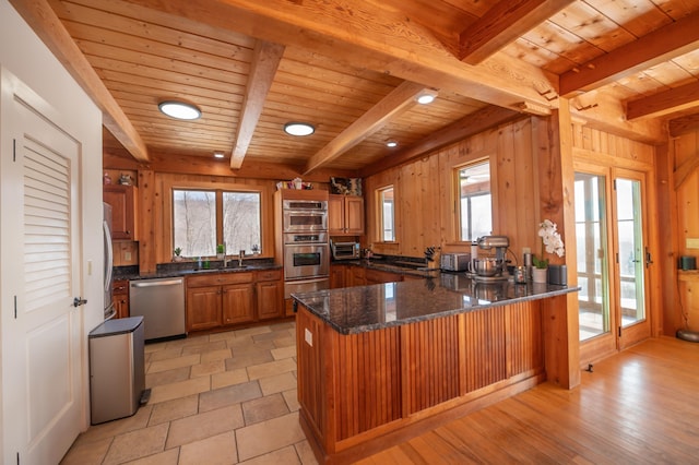 43 Upton Rd, Dover, VT 05356 - kitchen featuring appliances with stainless steel finishes, brown cabinetry, a peninsula, healthy amount of natural light, and a wooden ceiling with exposed beams