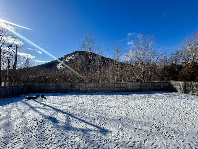 yard covered in snow featuring a mountain view