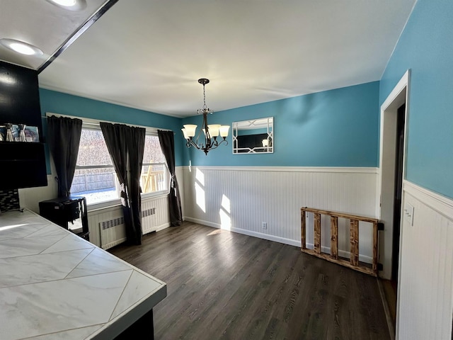 bedroom featuring radiator, a chandelier, and dark wood-type flooring