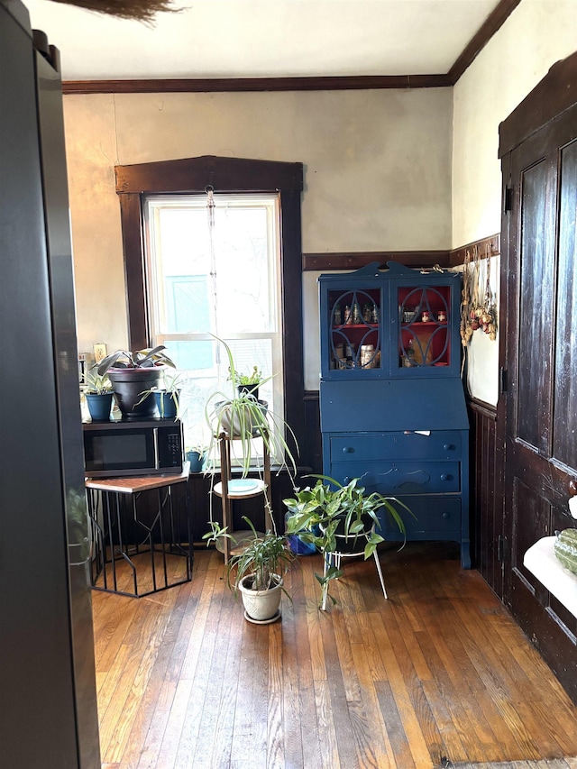 sitting room with ornamental molding and hardwood / wood-style flooring