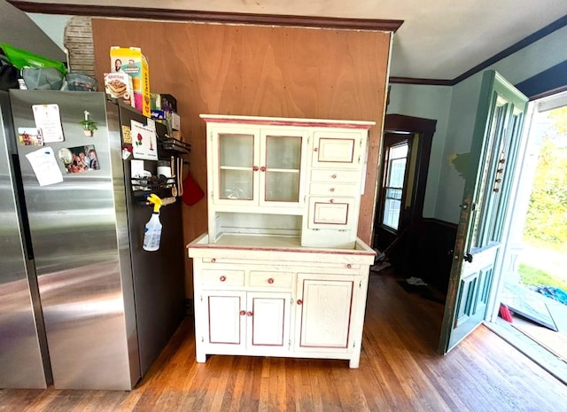 kitchen featuring white cabinets, light hardwood / wood-style flooring, stainless steel refrigerator, and ornamental molding