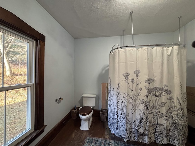 bathroom featuring hardwood / wood-style floors, a textured ceiling, and toilet