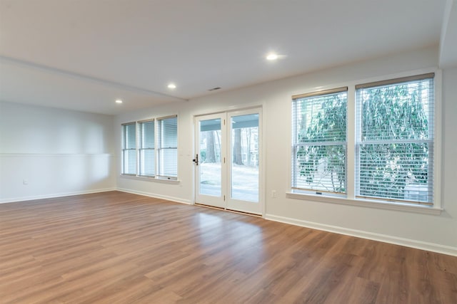 empty room featuring a wealth of natural light and hardwood / wood-style floors