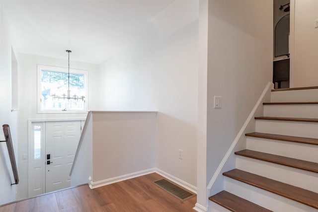 foyer entrance with an inviting chandelier and light hardwood / wood-style flooring