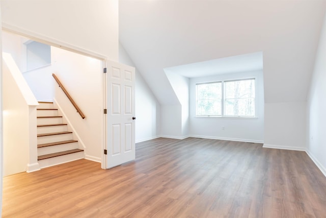 additional living space with vaulted ceiling and hardwood / wood-style flooring