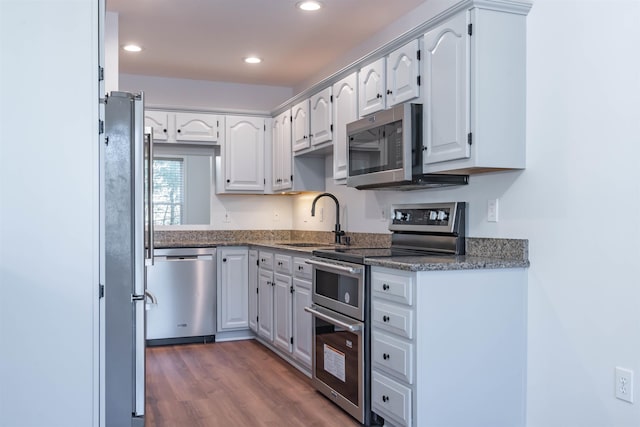 kitchen featuring appliances with stainless steel finishes, white cabinetry, dark wood-type flooring, and sink