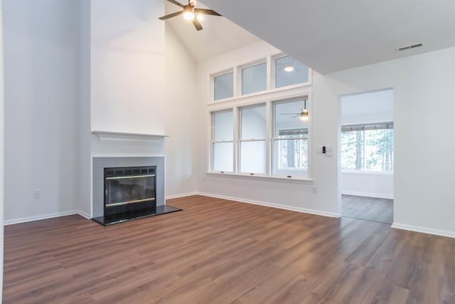 unfurnished living room featuring dark hardwood / wood-style flooring, lofted ceiling, and a fireplace