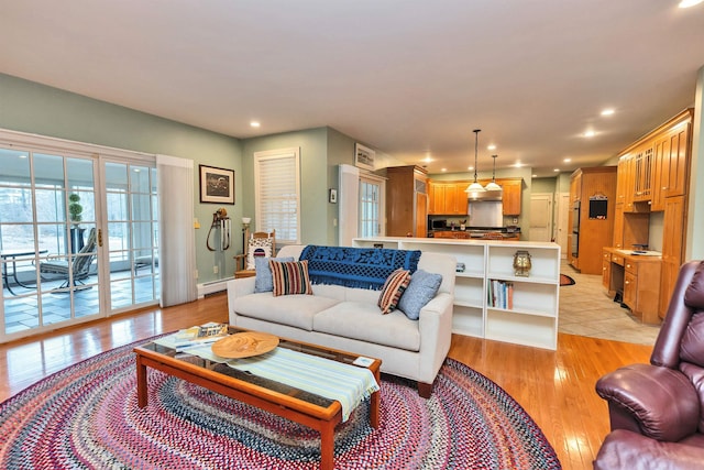 living room with light hardwood / wood-style floors and a baseboard heating unit