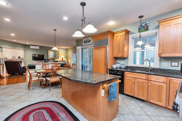 kitchen with a center island, sink, dark stone countertops, black dishwasher, and hanging light fixtures