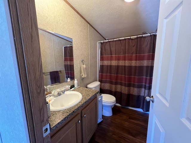 bathroom with hardwood / wood-style floors, vanity, toilet, a textured ceiling, and walk in shower