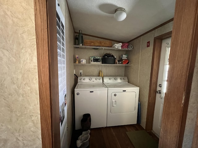 washroom featuring a textured ceiling, washing machine and dryer, dark hardwood / wood-style floors, and ornamental molding