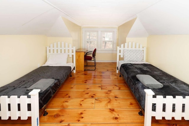 bedroom featuring hardwood / wood-style flooring and lofted ceiling